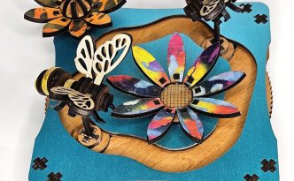 Magnetic spinner art with bees and flowers.